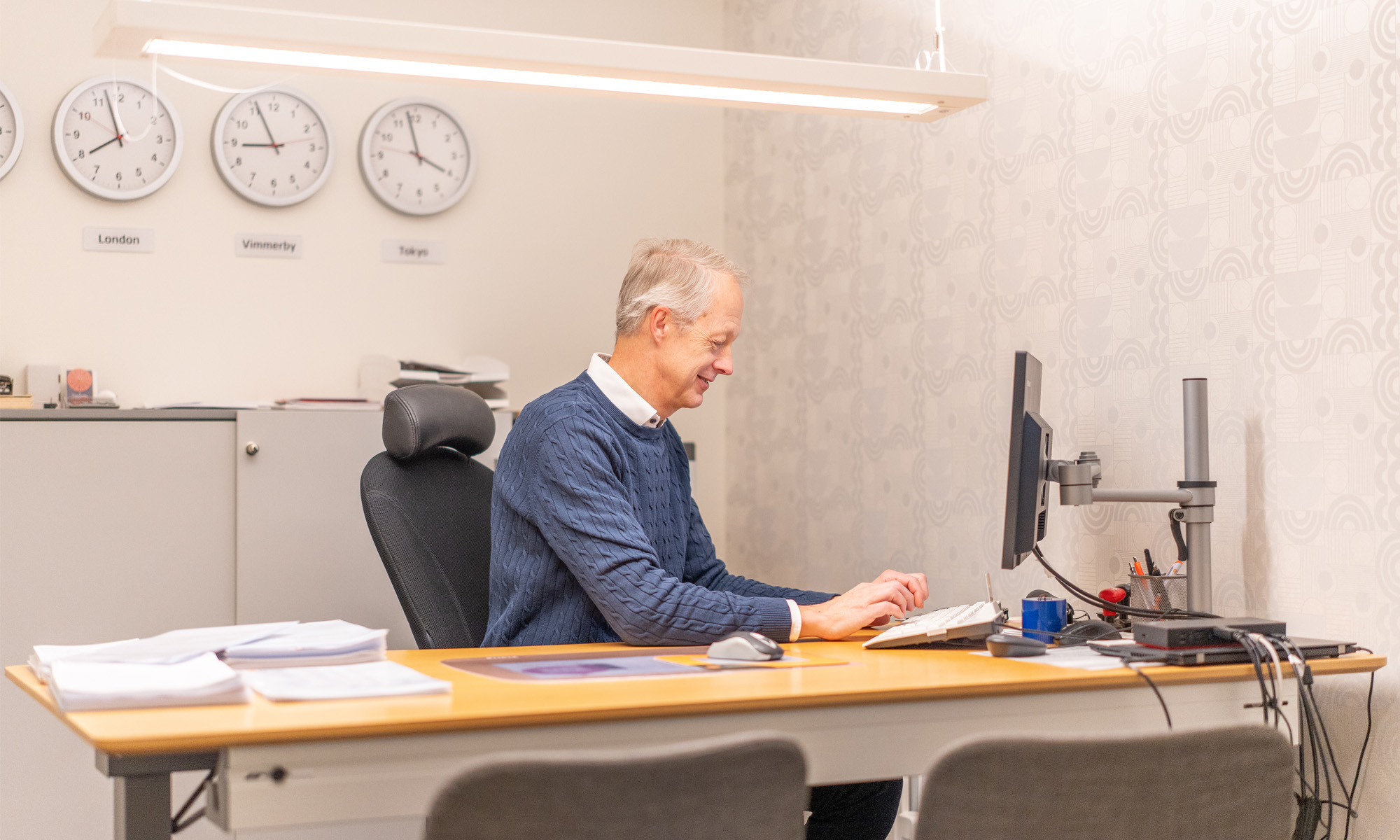 Man sitter framför en dator på ett kontor